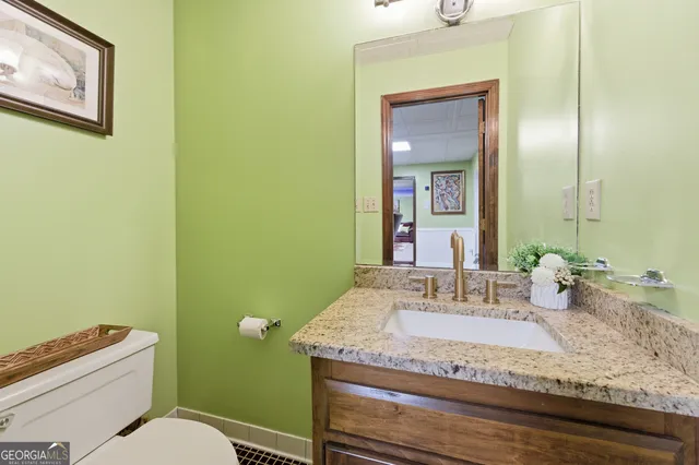 a bathroom with a granite countertop toilet sink and mirror