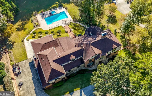 an aerial view of a house with a yard and swimming pool