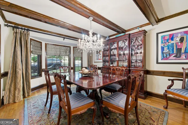a view of a dining room with furniture a chandelier and wooden floor