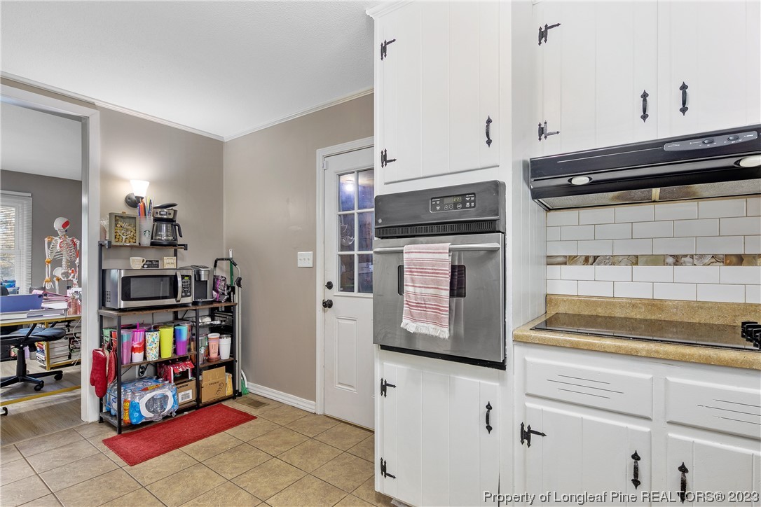 6433 Milford Road Fayetteville, NC 28303 - Photo 22 of 46 a kitchen with stainless steel appliances cabinets and a wooden floor