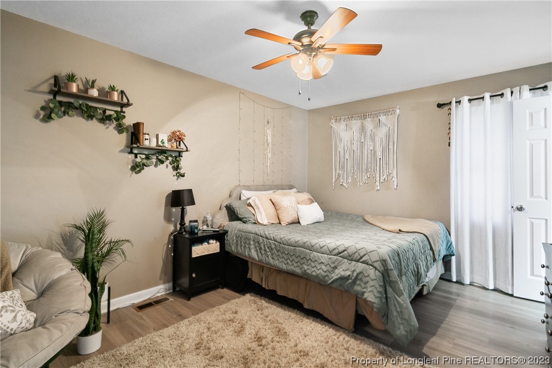 6433 Milford Road Fayetteville, NC 28303 - Photo 28 of 46 a bedroom with a bed and a chandelier