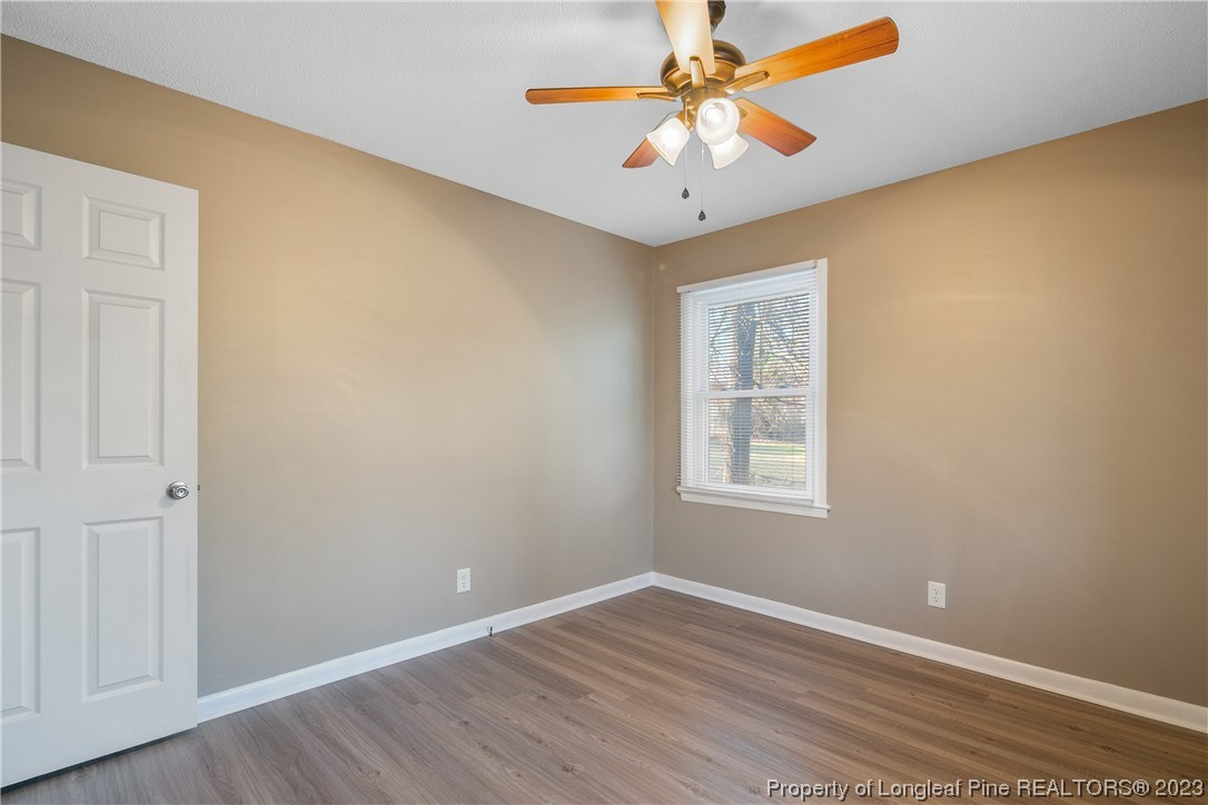 6433 Milford Road Fayetteville, NC 28303 - Photo 35 of 46 a view of an empty room with window and wooden floor