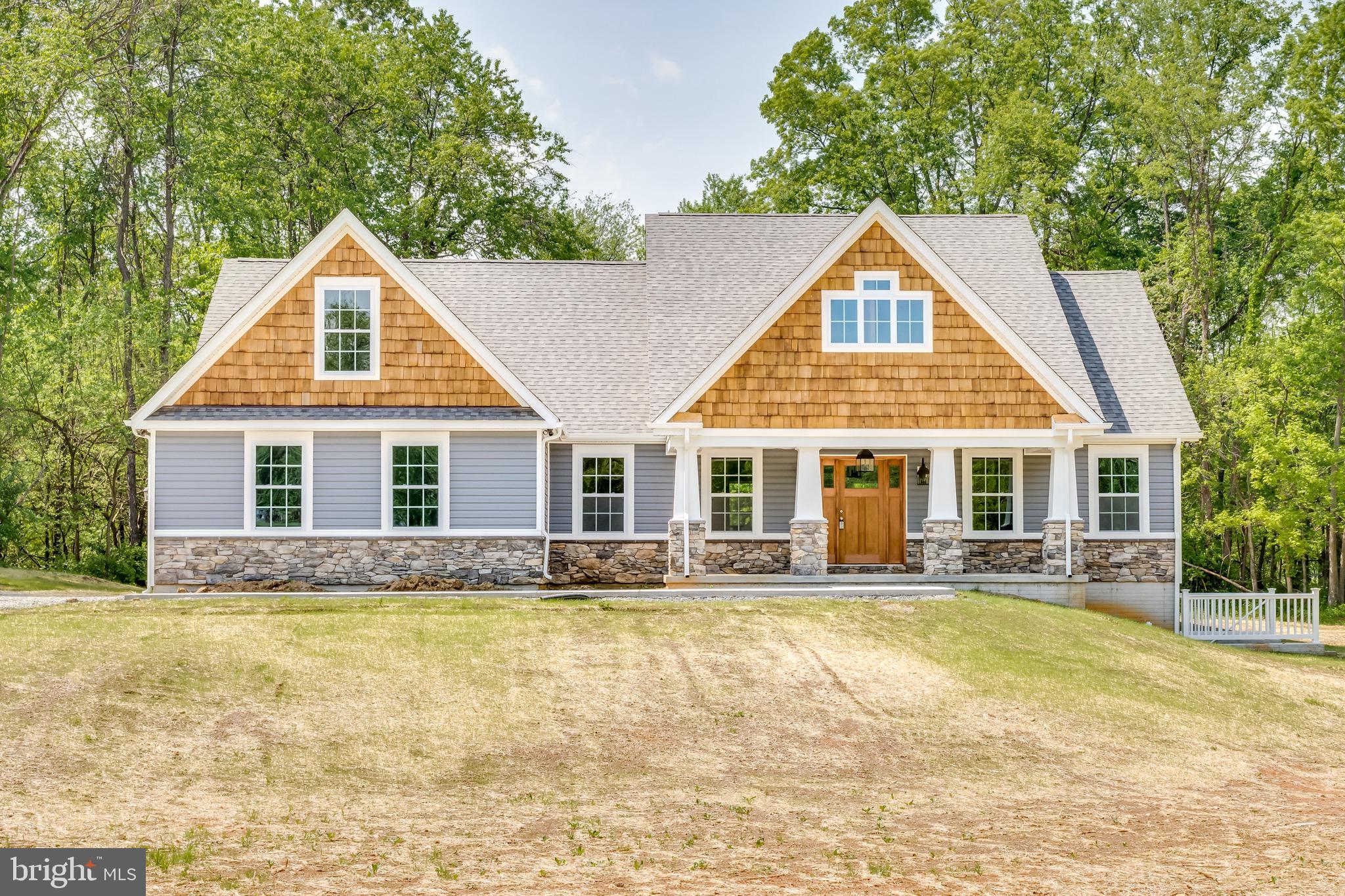 a front view of house with yard and trees around