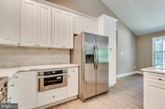 a kitchen with white cabinets and white appliances