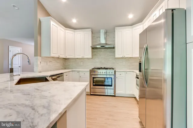 a kitchen with stainless steel appliances granite countertop a sink stove and refrigerator