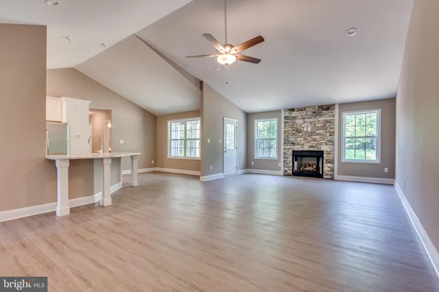 a view of empty room with wooden floor and fireplace