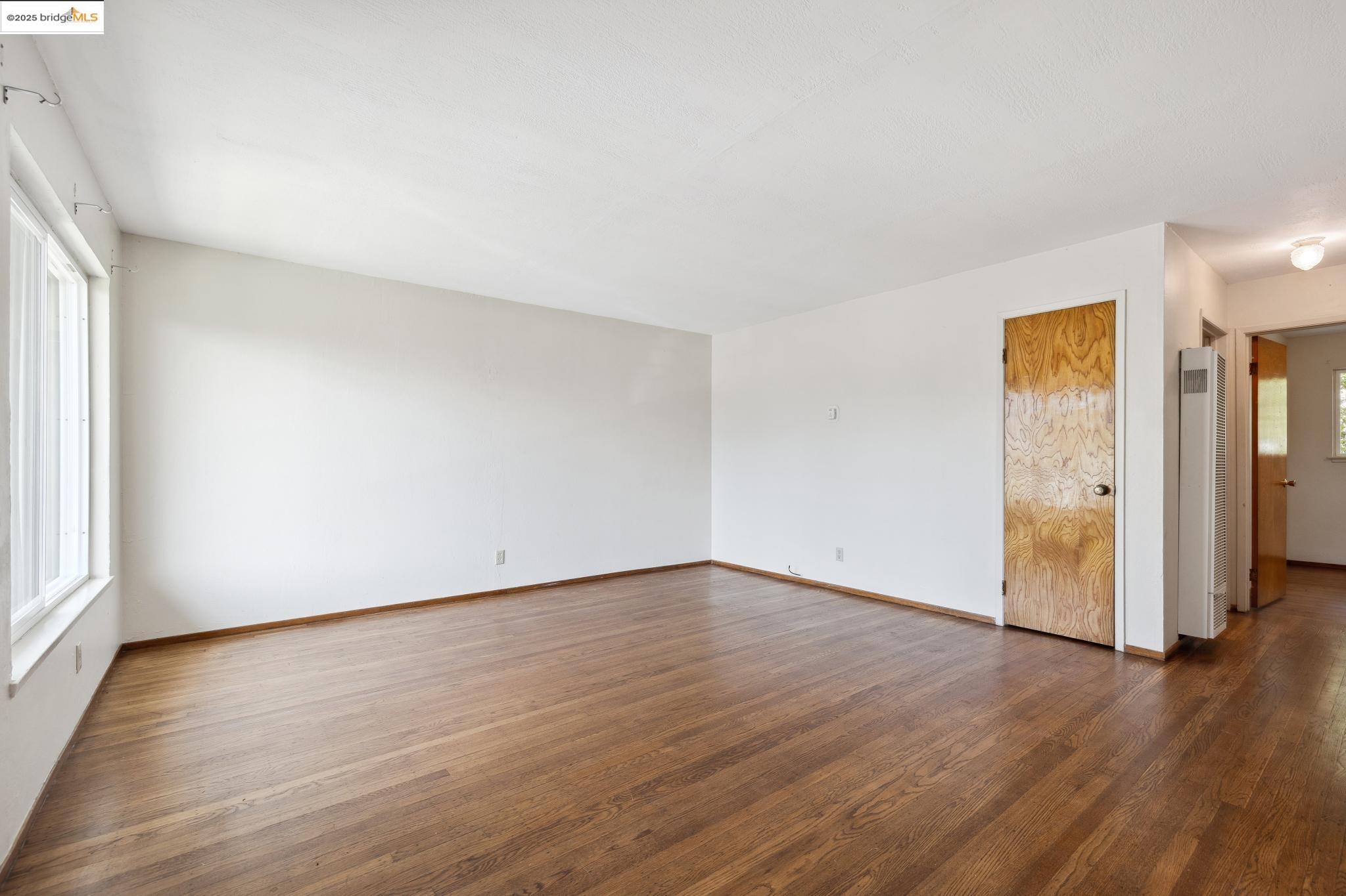 1612 Parker Street Berkeley, CA 94703 - Photo 2 of 16 a view of an empty room with wooden floor and a window