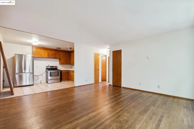 a view of a kitchen with a sink stove cabinets and empty room