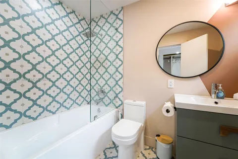 a bedroom with a bed and dresser with mirror