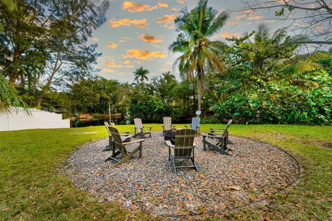a swimming pool with outdoor seating and trees