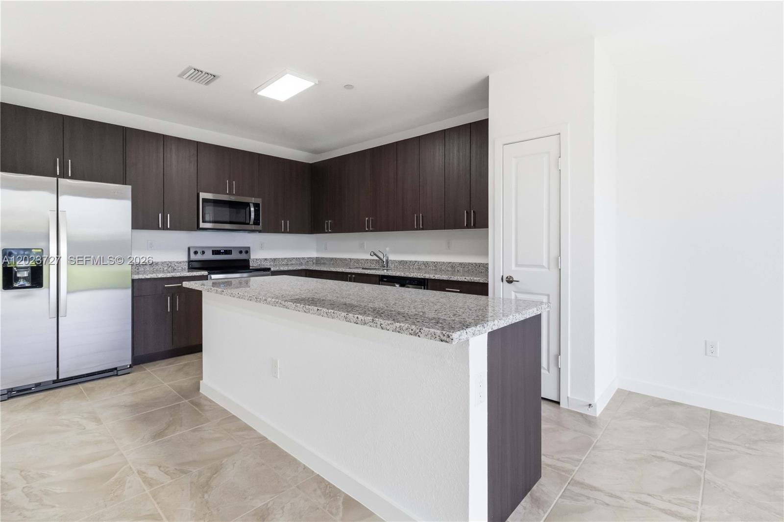 22348 Southwest 115th Court, Unit 22348 Miami, FL 33170 - Photo 9 of 37 a kitchen with stainless steel appliances granite countertop a refrigerator a stove a sink and a microwave