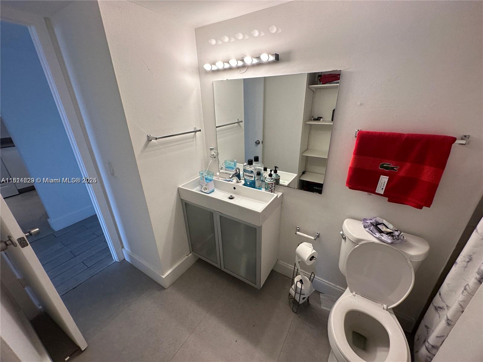 486 Northwest 165th Street, Unit B303 Miami, FL 33169 - Photo 4 of 12 a bathroom with a sink mirror and vanity