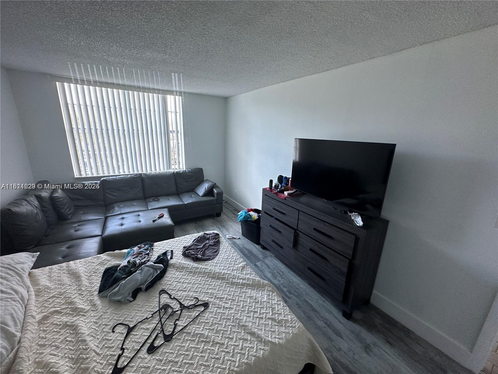 486 Northwest 165th Street, Unit B303 Miami, FL 33169 - Photo 6 of 12 a living room with furniture and a flat screen tv