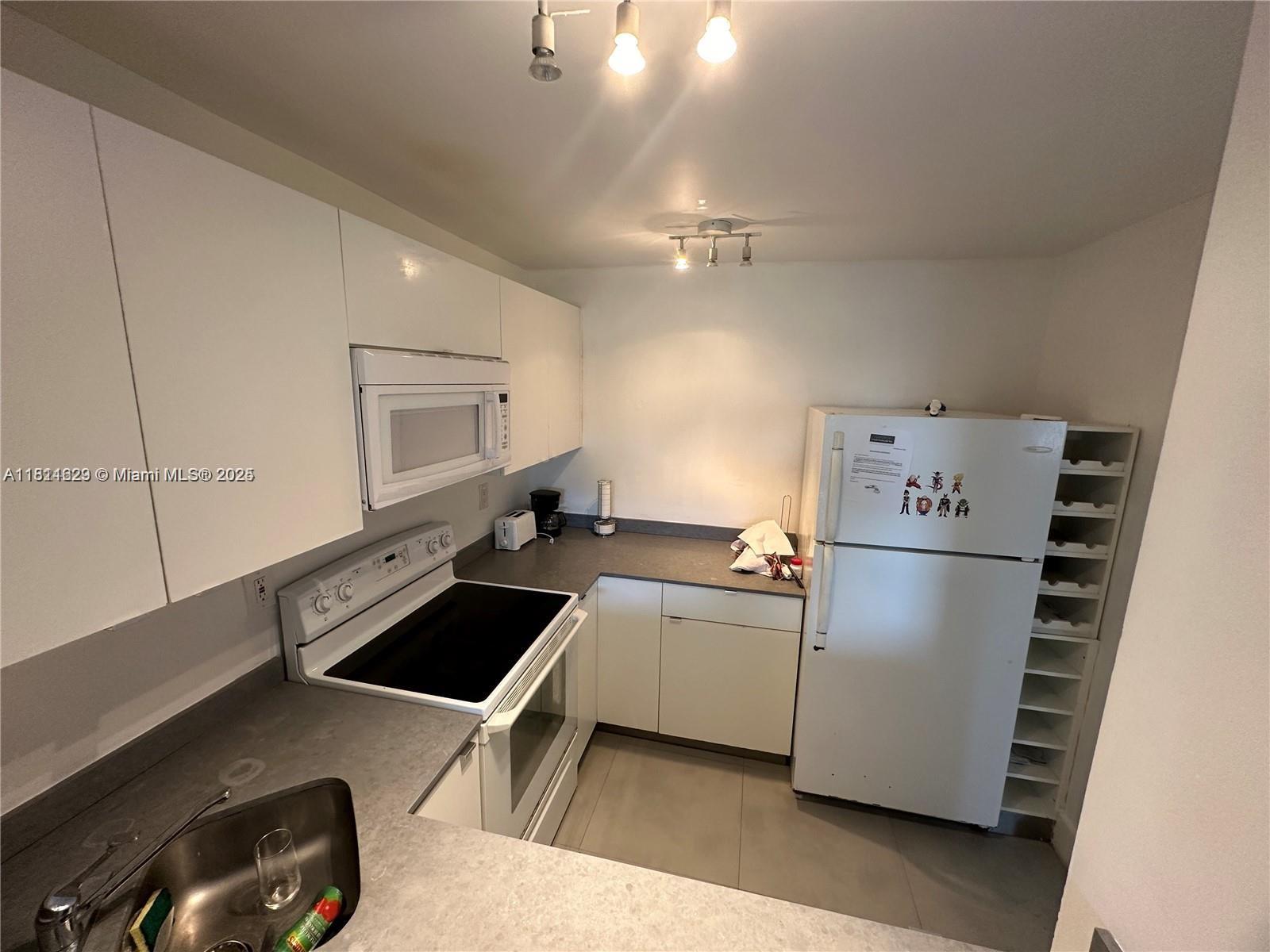 486 Northwest 165th Street, Unit B303 Miami, FL 33169 - Photo 10 of 12 a kitchen with a refrigerator and a sink