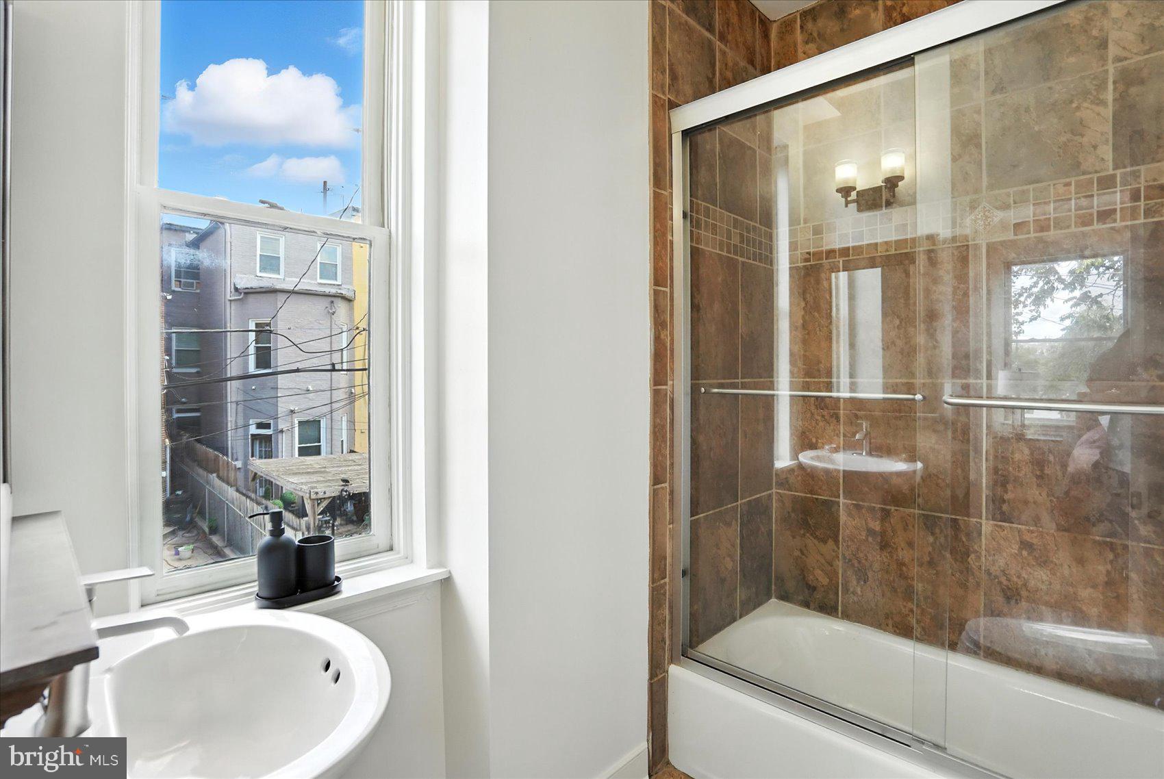 416 Mosher Street Baltimore, MD 21217 - Photo 19 of 38 a bathroom with a sink mirror and a shower