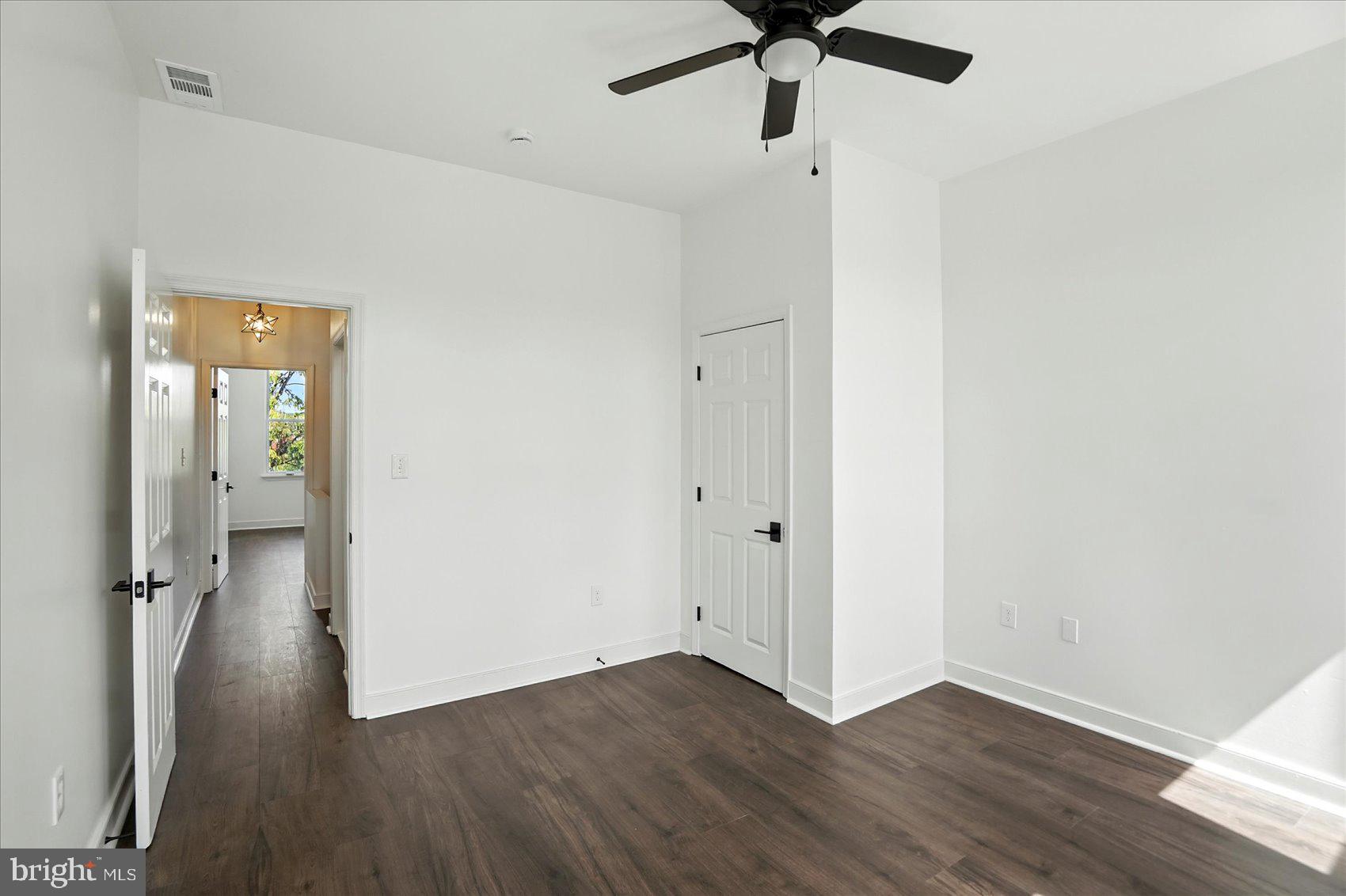416 Mosher Street Baltimore, MD 21217 - Photo 29 of 38 an empty room with wooden floor a ceiling fan and a window