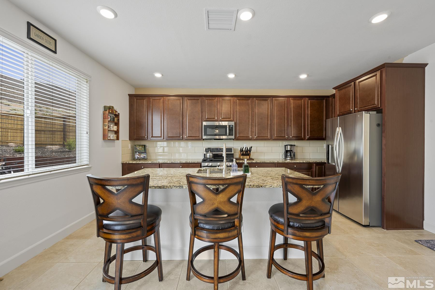 10370 Gold Mine Drive Reno, NV 89521 - Photo 5 of 31 a kitchen with stainless steel appliances granite countertop a refrigerator and a stove top oven with wooden floors