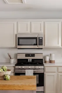 a kitchen with stainless steel appliances granite countertop a stove a microwave and cabinets