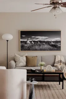 a living room with furniture and a wall painting