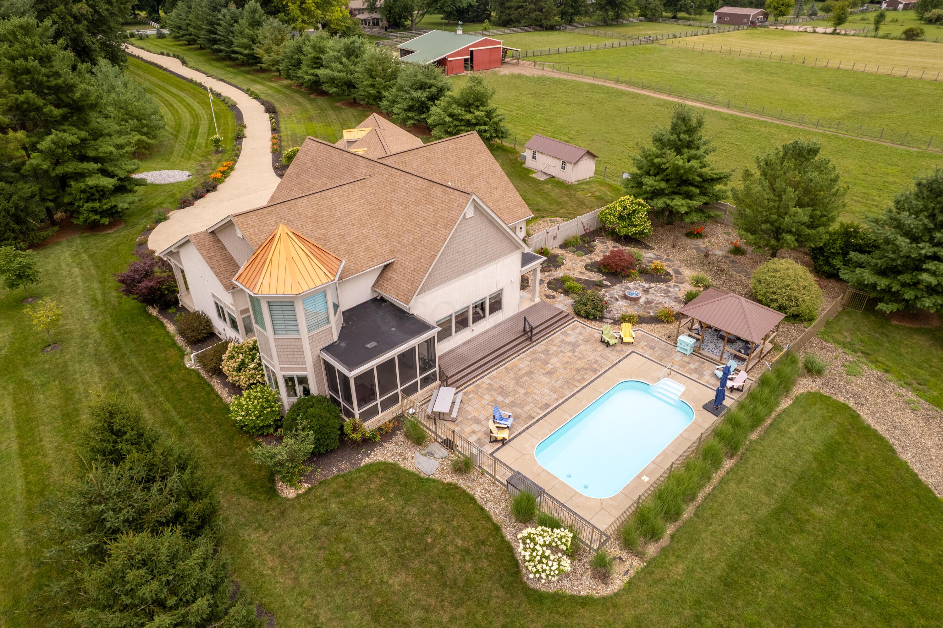 4640 Maynard Road Delaware, OH 43015 - Photo 3 of 91 Expansive property featuring a large in-ground pool with stone paver surround, a screened-in porch, and a dedicated patio area
