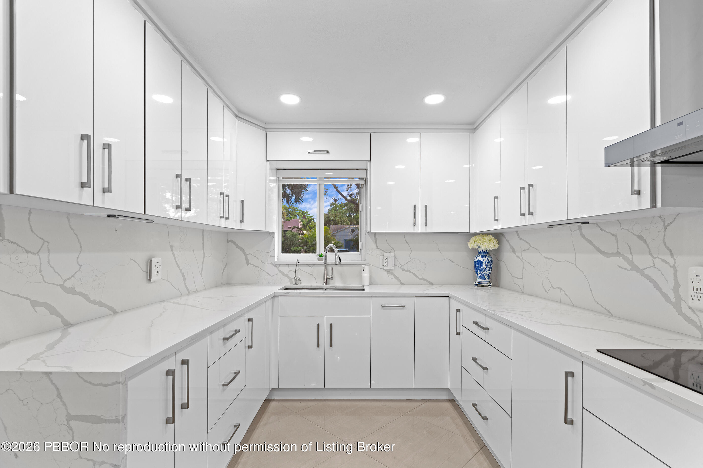 747 Avon Road West Palm Beach, FL 33401 - Photo 4 of 29 a kitchen with a sink dishwasher and white cabinets with wooden floor