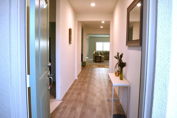 a view of hallway with furniture and wooden floor