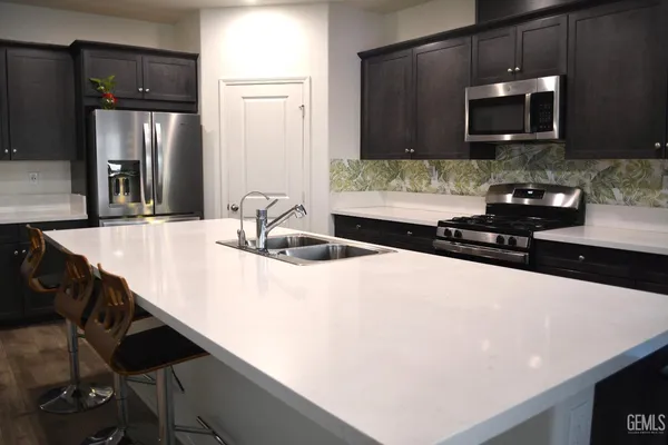 a kitchen with a sink a microwave and cabinets