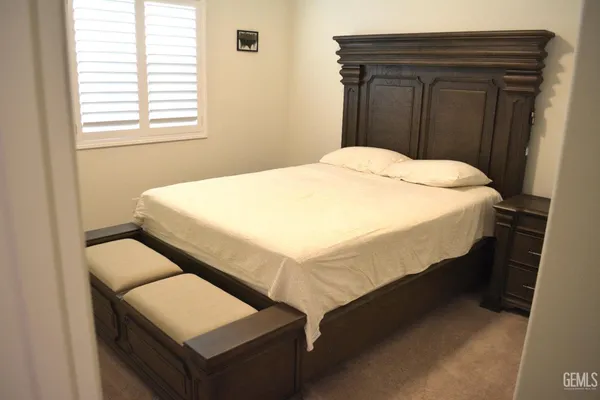 a bed sitting in a bedroom next to a window