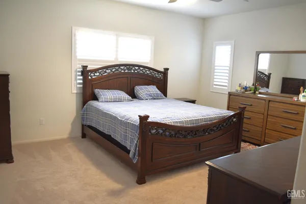 a bedroom with a bed a window and dresser