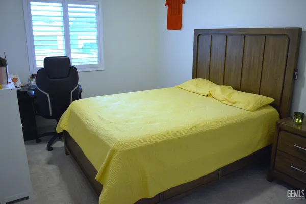 a bed sitting in a bedroom next to a window