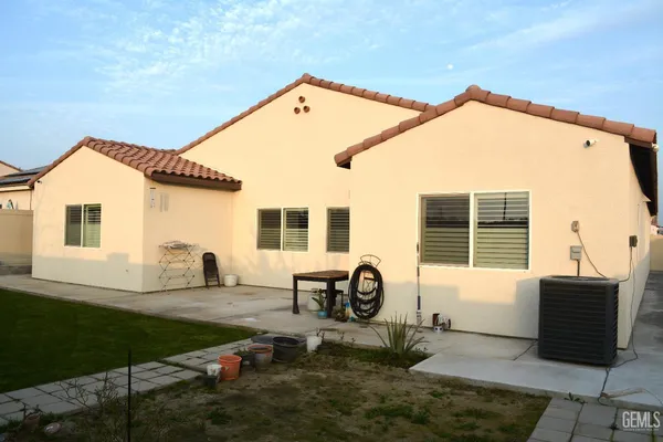 a view of a house with backyard and sitting area