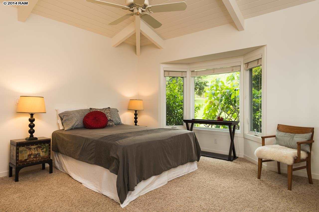 8037 Kula Highway Kula, HI 96790 - Photo 28 of 30 a bedroom with a bed and a chandelier