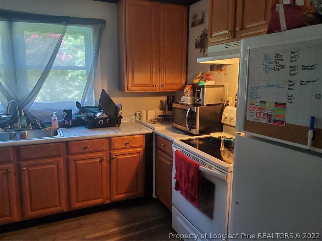 1920 Sapona Road Fayetteville, NC 28312 - Photo 5 of 15 a kitchen with stainless steel appliances granite countertop a sink a stove and wooden cabinets