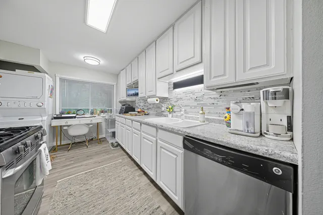 a kitchen with stainless steel appliances granite countertop a sink stove and cabinets