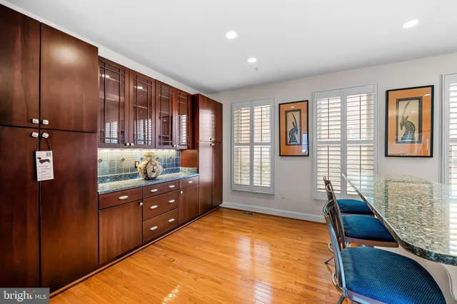 a kitchen island with granite countertop a sink a counter top space and stainless steel appliances
