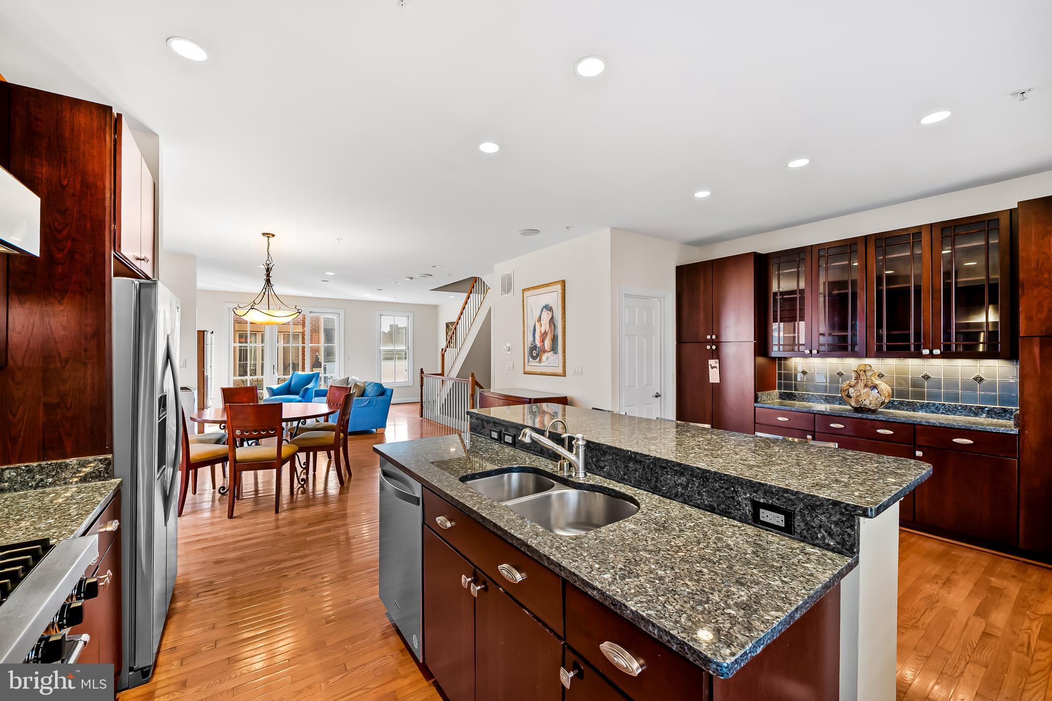2323 Boston Street, Unit 6 Baltimore, MD 21224 - Photo 7 of 47 a kitchen island with granite countertop a sink a counter top space and stainless steel appliances