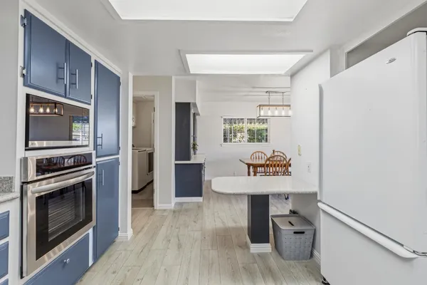 a kitchen with stainless steel appliances a stove a refrigerator and a microwave