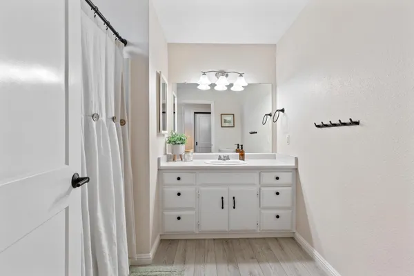a bathroom with a double vanity sink mirror and shower