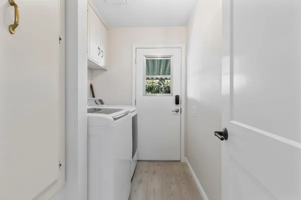 a view of a bathroom with sink window and wooden floor