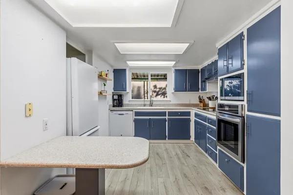 a kitchen with a refrigerator and a stove top oven