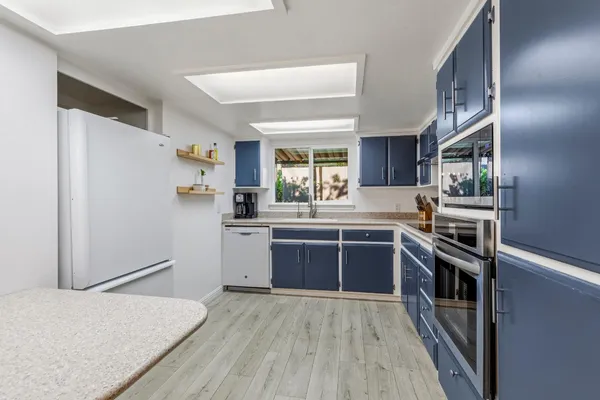 a kitchen with stainless steel appliances granite countertop a refrigerator and a stove
