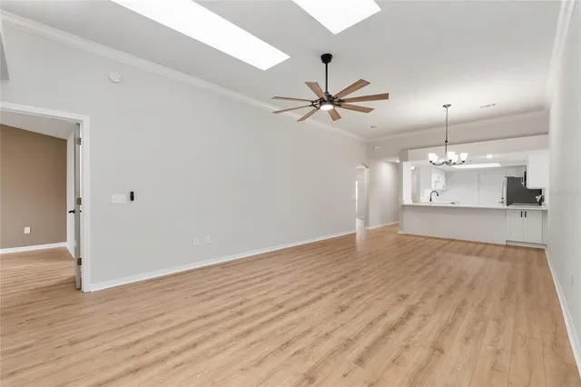 a view of a room with wooden floor chandelier and a window