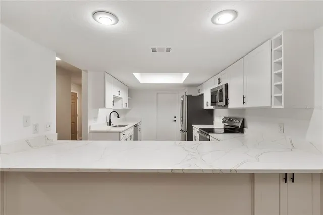 a kitchen with stainless steel appliances granite countertop a sink stove and cabinets