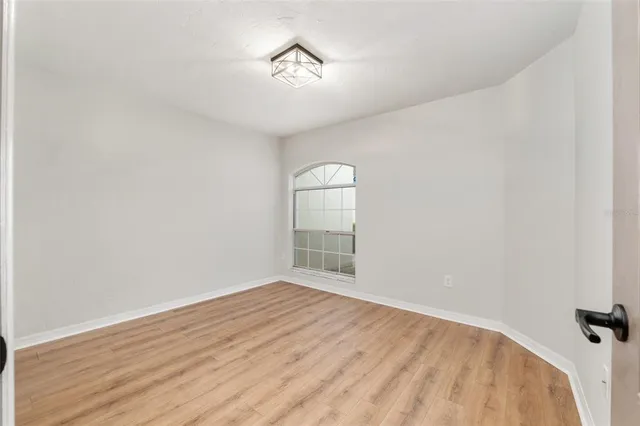 a view of hallway with a large window and wooden floor