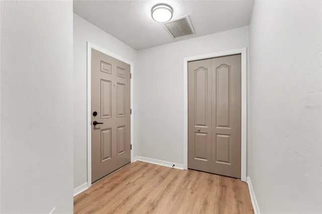 a view of a hallway with wooden floor and staircase