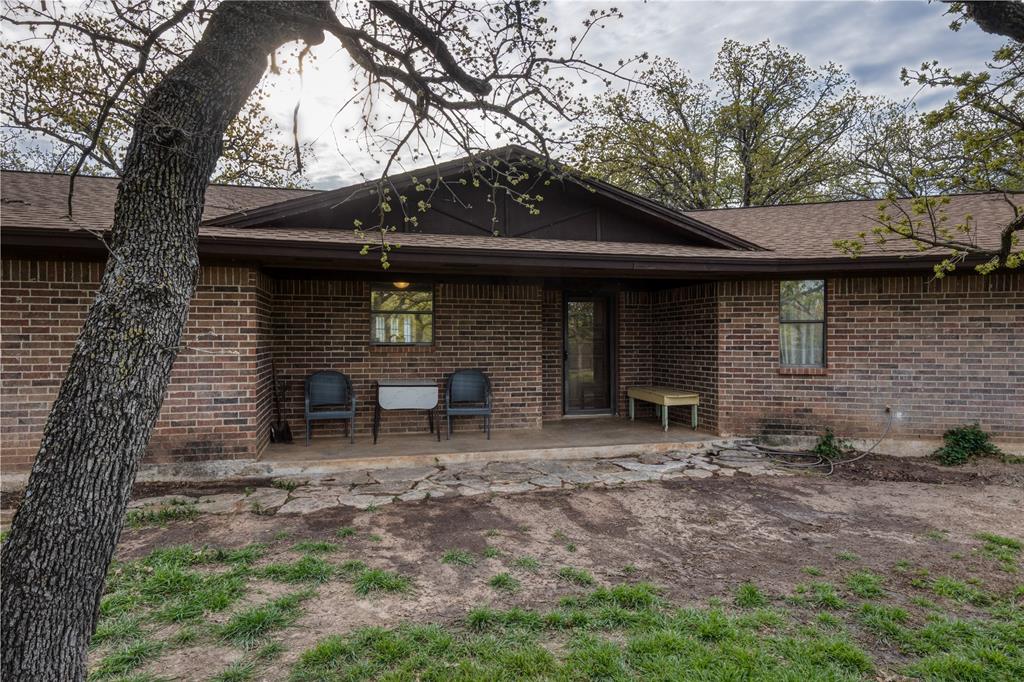 243 County Road 3851 Poolville, TX 76487 - Photo 4 of 34 a front view of a house with garden