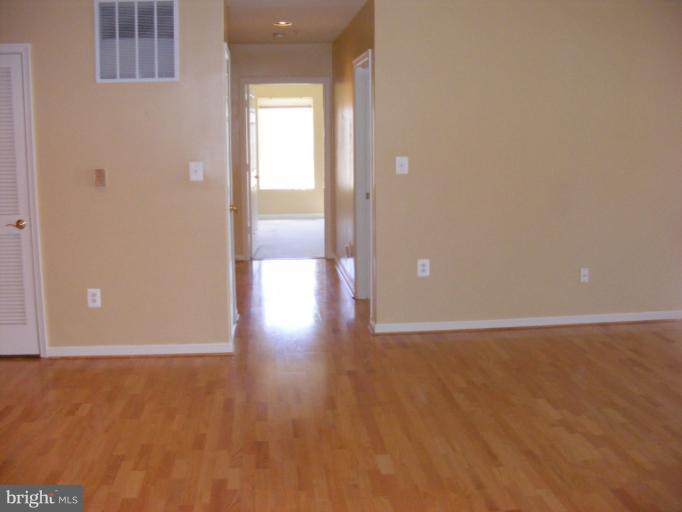 12000 Tralee Road, Unit 304 Lutherville-Timonium, MD 21093 - Photo 7 of 9 a view of an empty room with wooden floor and a bathroom