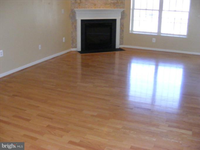 12000 Tralee Road, Unit 304 Lutherville-Timonium, MD 21093 - Photo 8 of 9 an empty room with wooden floor and windows