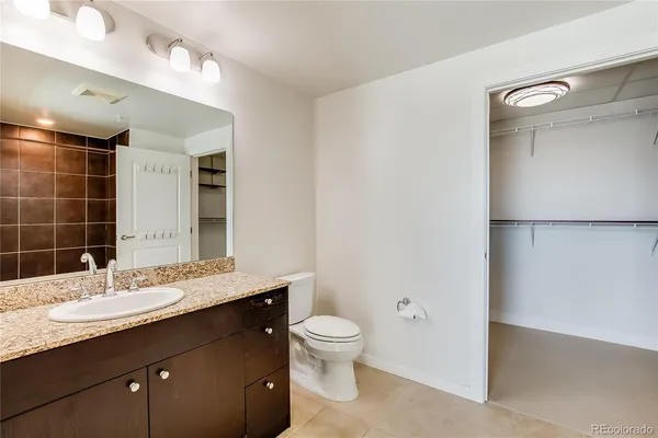a bathroom with a granite countertop sink toilet a large mirror and shower