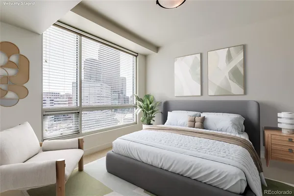 a bedroom with a large bed couch and a large window